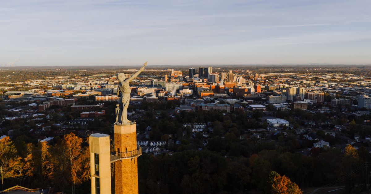 Drone capture of the Vulcan statue with Birmingham city skyline at sunset, Alabama.